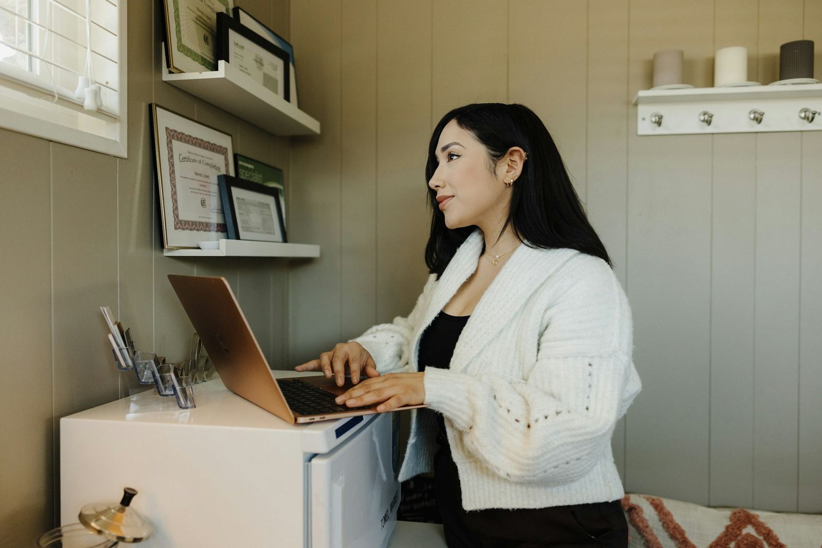 A small-business owner checking enquiries on her laptop in her studio